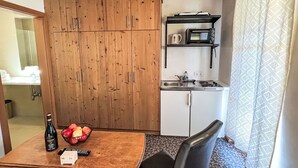 Eine kleine Küche mit Holzschränken, einer Mikrowelle und einem Spülbecken.
