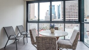 Une pièce moderne dotée d’une grande fenêtre, d’une table ronde et de quatre chaises.