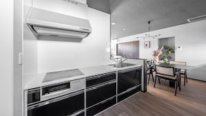 Una cocina moderna con horno empotrado, un lavamanos y un comedor con mesa y sillas.