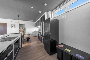 Una cocina moderna con un refrigerador de acero inoxidable, un comedor con mesa y sillas, y un horno empotrado.