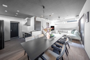 Una cocina moderna con comedor, sofá y televisor.