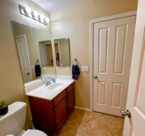 A bathroom with a white sink, mirror, and wooden cabinets. - Sunny Maricopa spacious Vacation Home. Clean 3Bd/2Bath. Close to everything (Maricopa)
