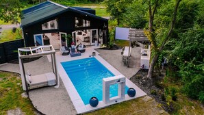 A modern house with a swimming pool, outdoor seating, and a pergola. - Luxury Getaway in East Texas, Pool • Jacuzzi (Bullard)