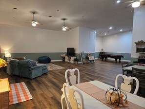 A spacious living room with a sofa, a dining table with chairs, a pool table, and ceiling fans. - 10 Private Acres -5 Min to World Equestrian Center - Firepit & Trailer Parking (Wilmington)