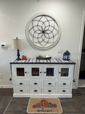 A white cabinet with multiple drawers and a decorative welcome mat featuring pumpkins. - Beautiful Brand new! NO STAIRS Next to SDC! 2 king rooms queen sofa 2 full baths (Branson)