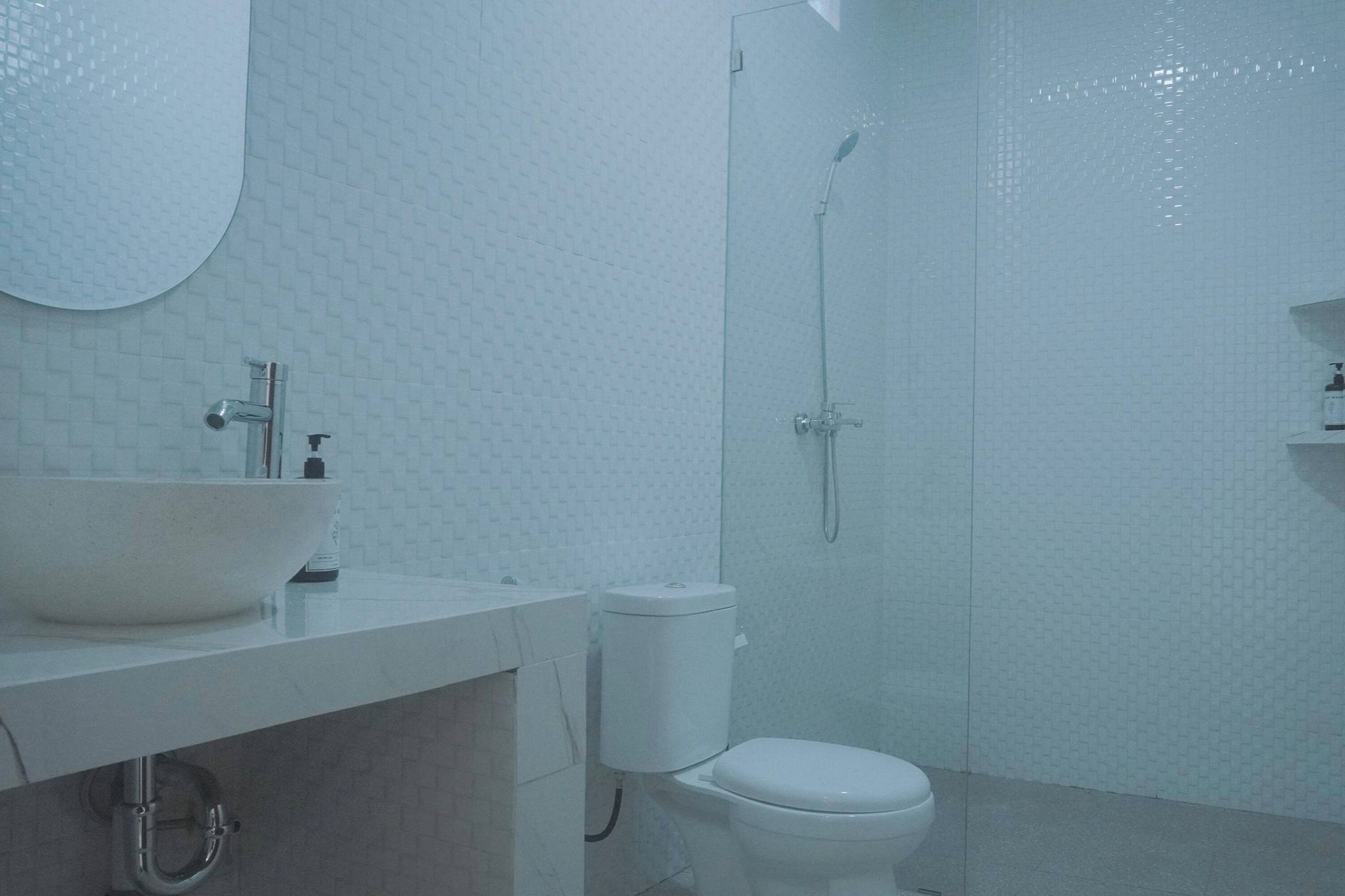 A bathroom with a white sink, toilet, and shower.