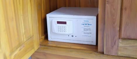 A white microwave with a digital display and control panel, placed on a wooden surface.