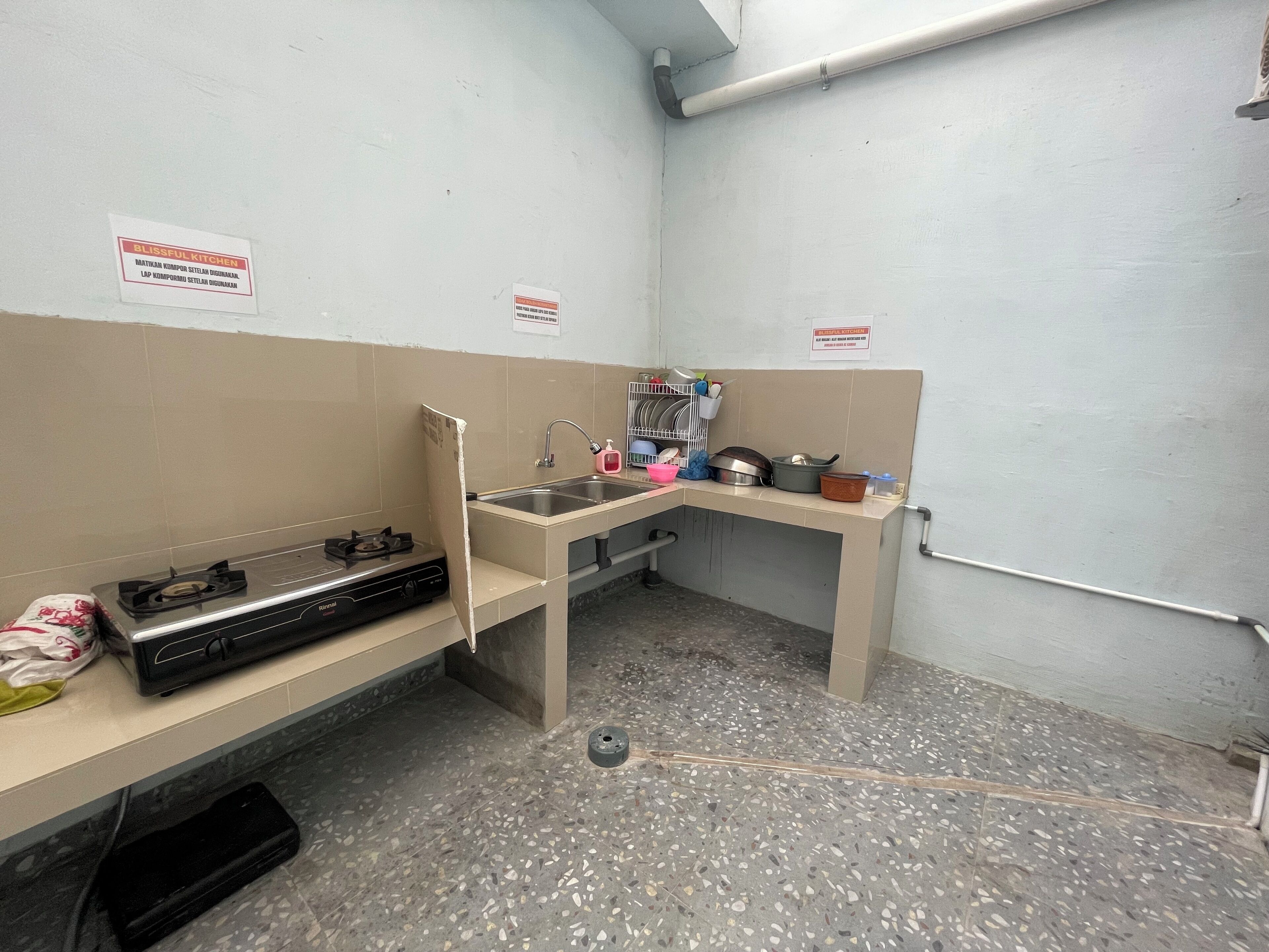 A compact kitchenette with a gas stove, sink, and a small countertop.