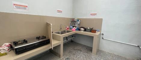 Une petite cuisine équipée avec une cuisinière à gaz, un évier et un petit plan de travail.