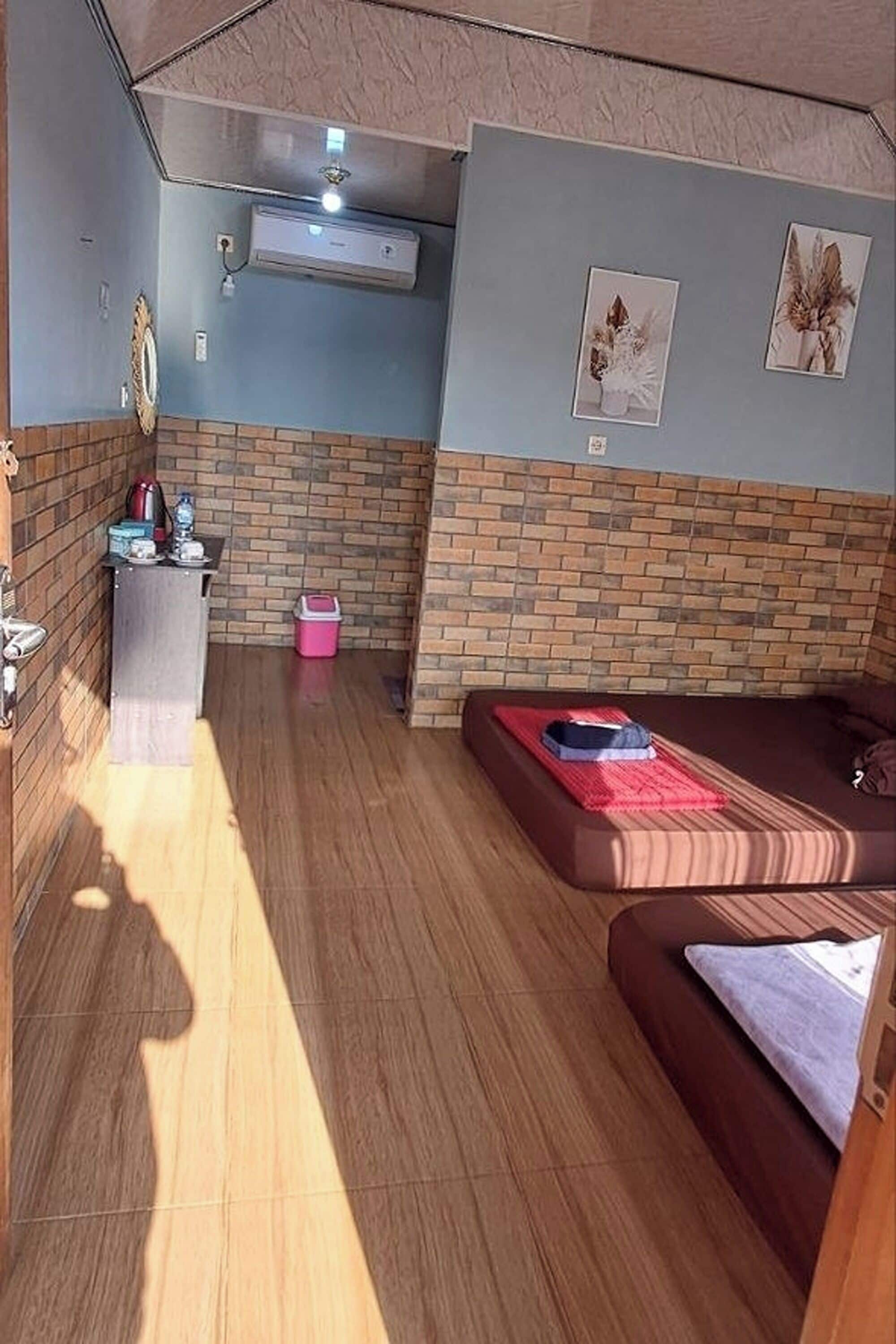 A compact living space with a sofa, a small table, and a brick-patterned wall.