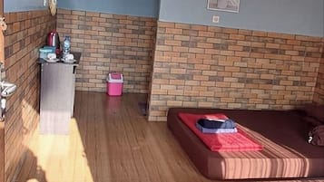 A compact living space with a sofa, a small table, and a brick-patterned wall.