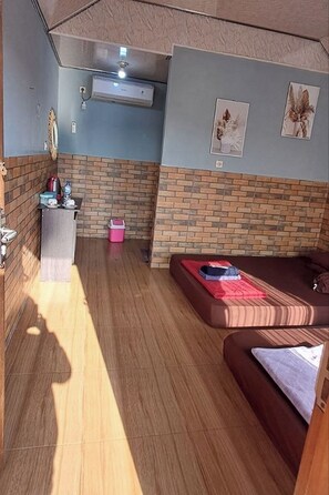 Un espacio habitable compacto con un sofá, una mesita y una pared con diseño de ladrillo.