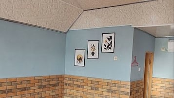 Ein Zimmer mit einem Bett, einer Ziegelwand und einer Tür.