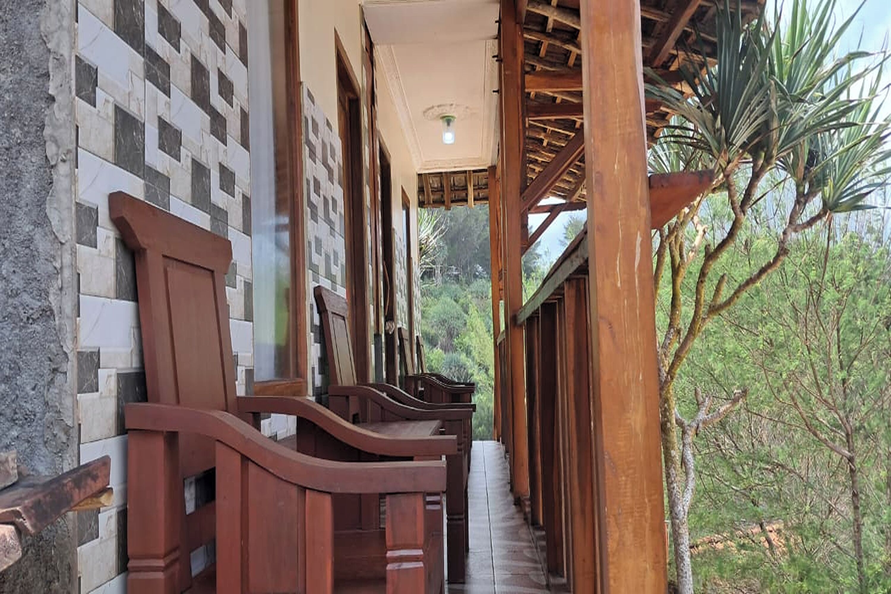 A corridor with wooden benches and a tiled wall.