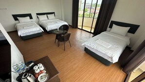A hotel room with two single beds, a small table with a chair, and a view of the city through large windows. - Glistar Hotel (Tampin)
