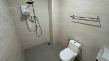 Un baño pequeño y moderno con inodoro, ducha y toallero.
