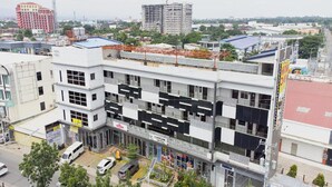 A multi-story building with a modern architectural design, featuring a mix of commercial and residential spaces. - Madison Suites Mactan Cebu (Lapu-Lapu)