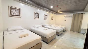 Habitación cuádruple Deluxe | Escritorio, wifi gratis y ropa de cama