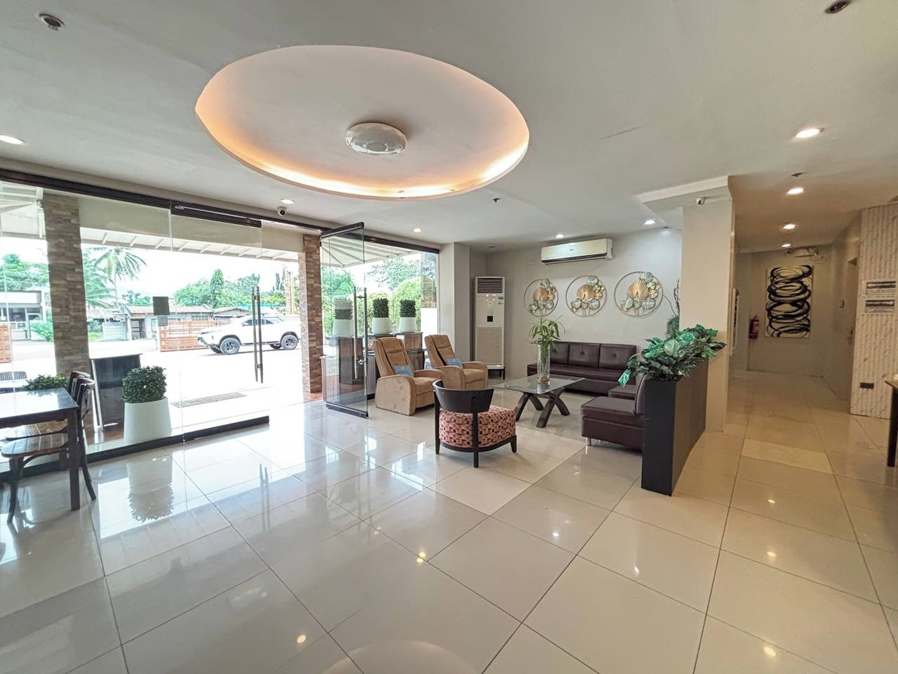 A modern lobby with a glass entrance, seating area, and decorative wall art.