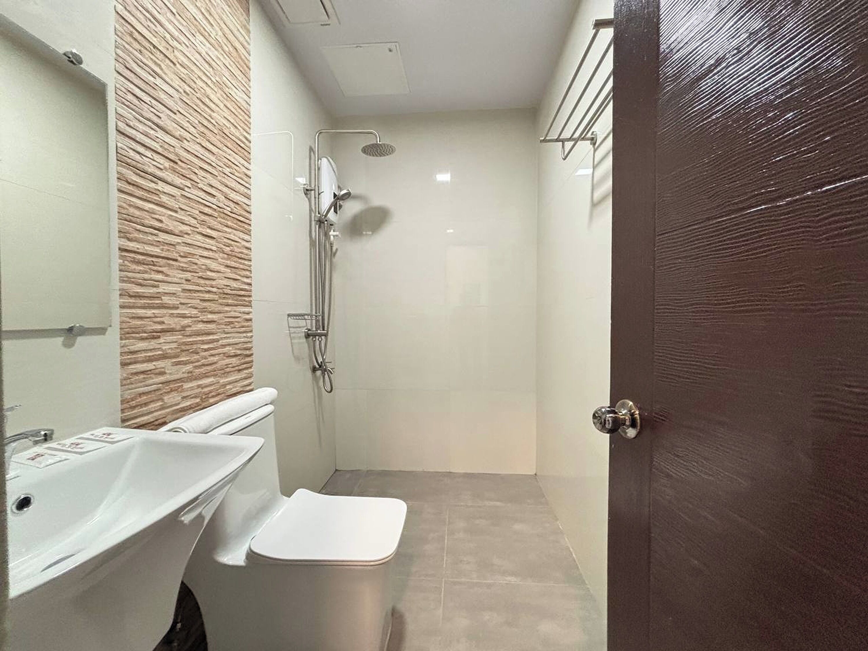 A modern bathroom with a shower, toilet, and sink.
