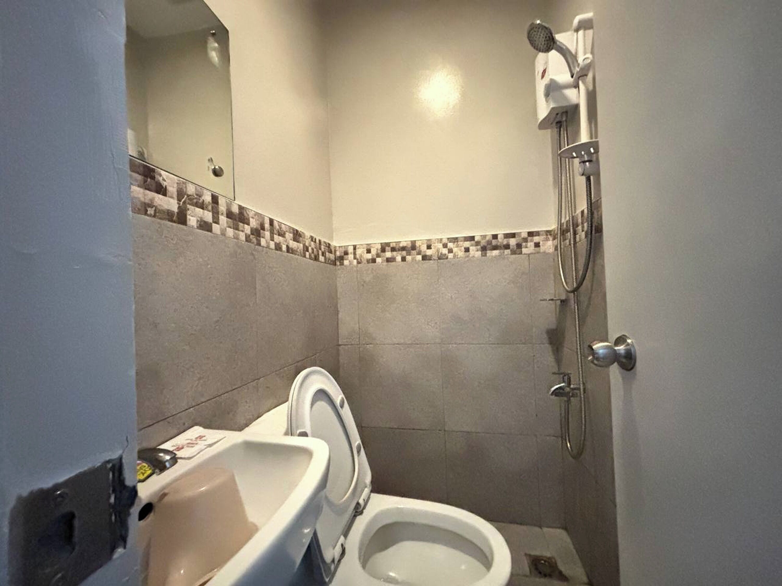 Un baño pequeño con inodoro, lavabo y ducha.