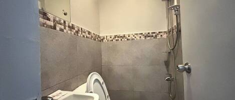 Un baño pequeño con inodoro, lavabo y ducha.