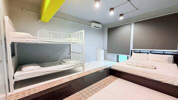A hotel room with bunk beds, a large window, and a modern design.