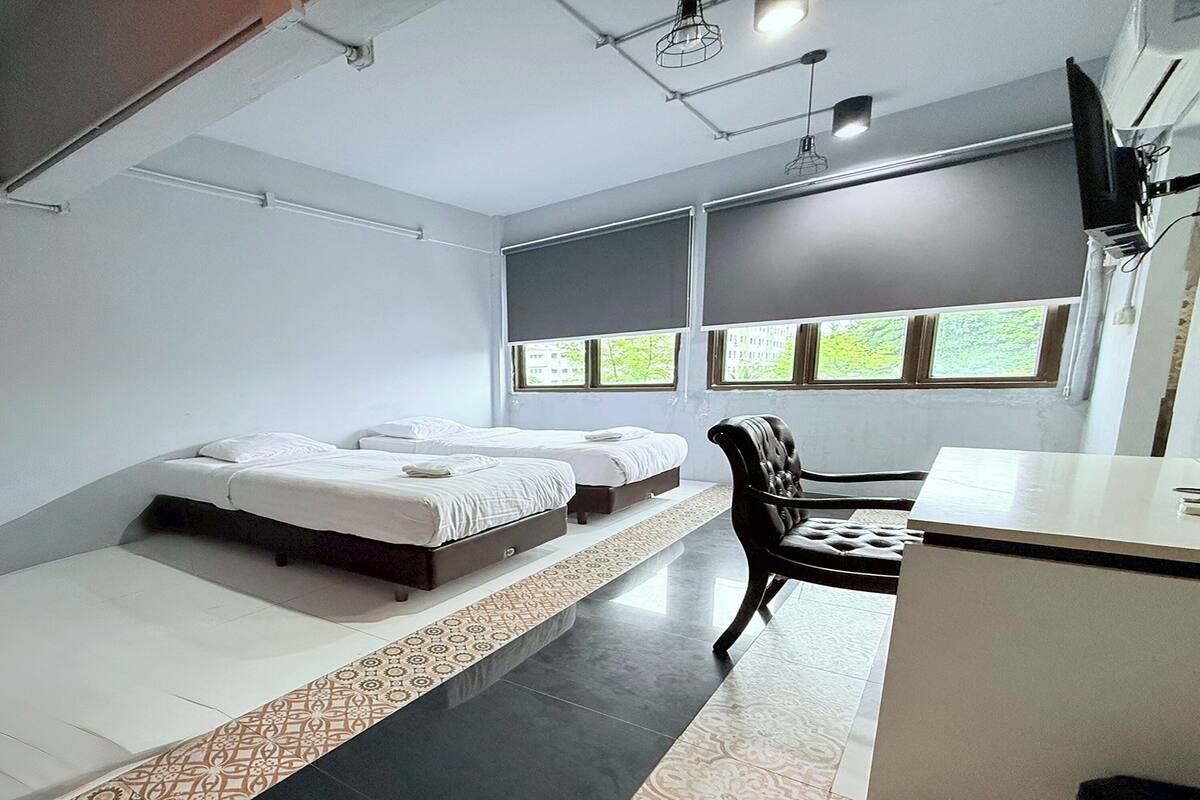 A room with two beds, a desk, and a chair.