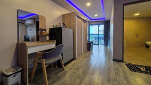 A modern kitchen with a built-in stove, a refrigerator, and a wooden countertop. - Central Guesthouse Chiang Rai (Chiang Rai)