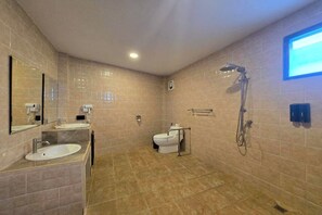 Un bagno moderno con due lavandini, un water e una doccia.
