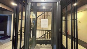 A revolving door with a sign on the wall. - Central Guesthouse Chiang Rai (Chiang Rai)