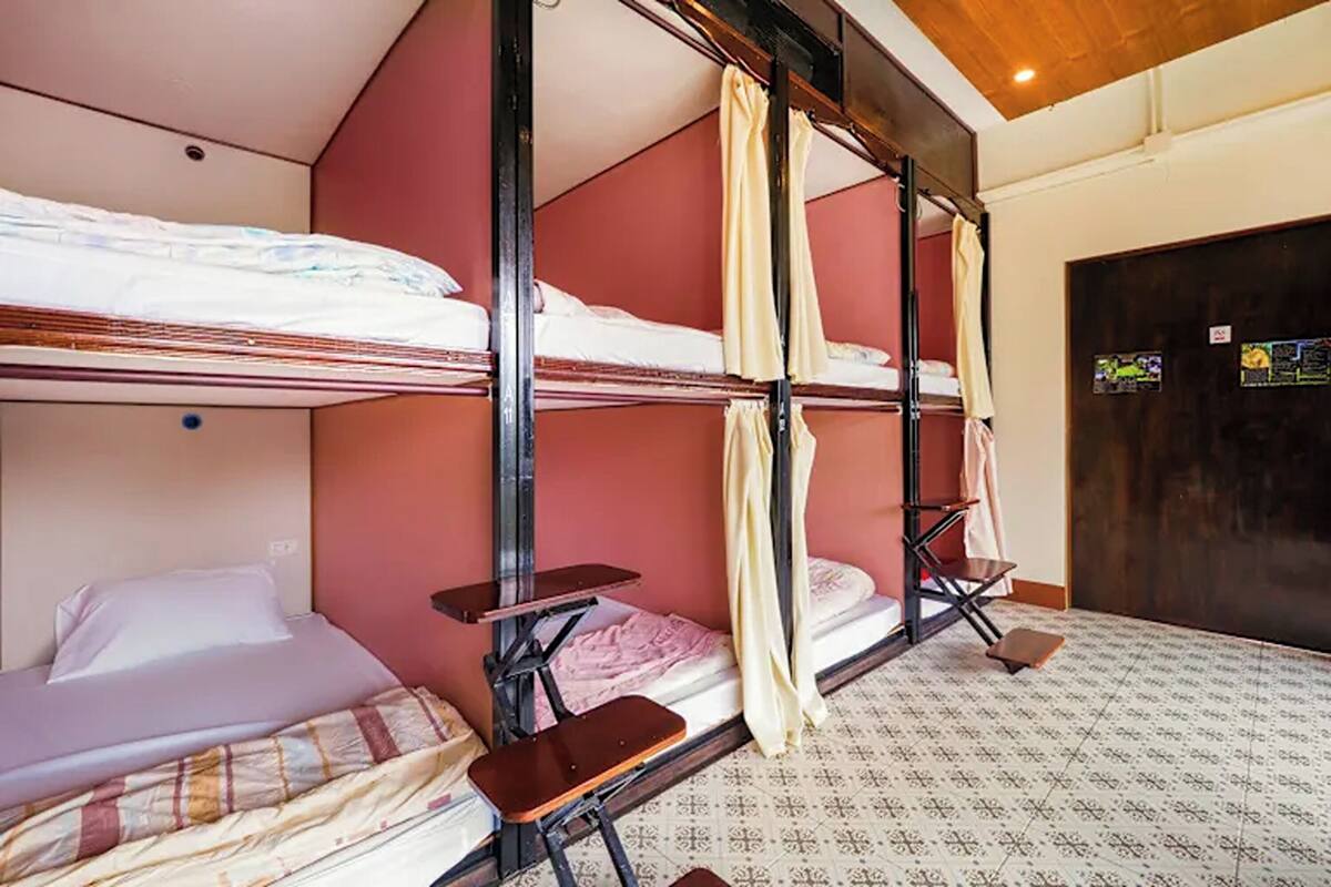 Habitación con literas, techo de madera y piso estampado.