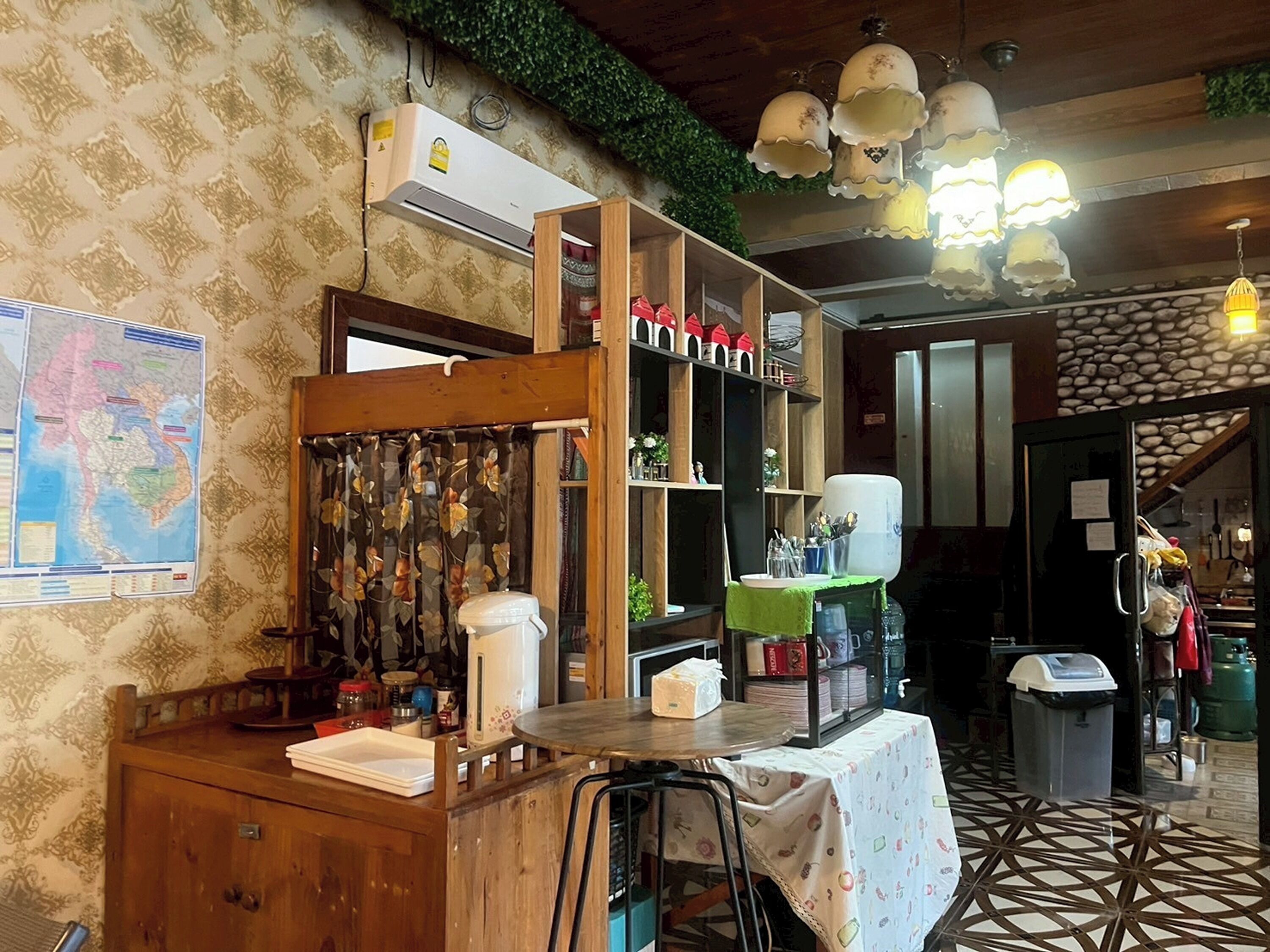 Un intérieur rustique avec un comptoir en bois, une carte accrochée au mur et un sol carrelé.