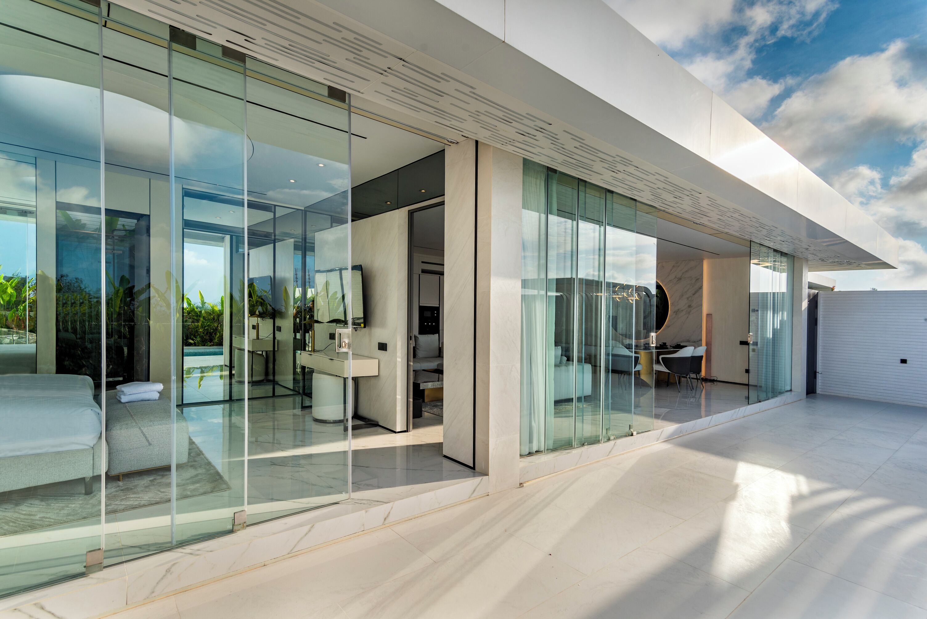 Une maison moderne dotée de grandes baies vitrées, d’un vaste espace de vie et offrant une vue sur l’extérieur.