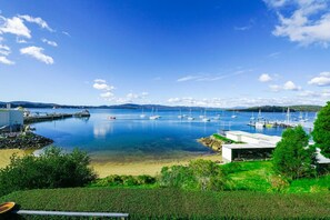 Un port de plaisance situé sur la côte, avec des bateaux, une jetée et un petit bâtiment.