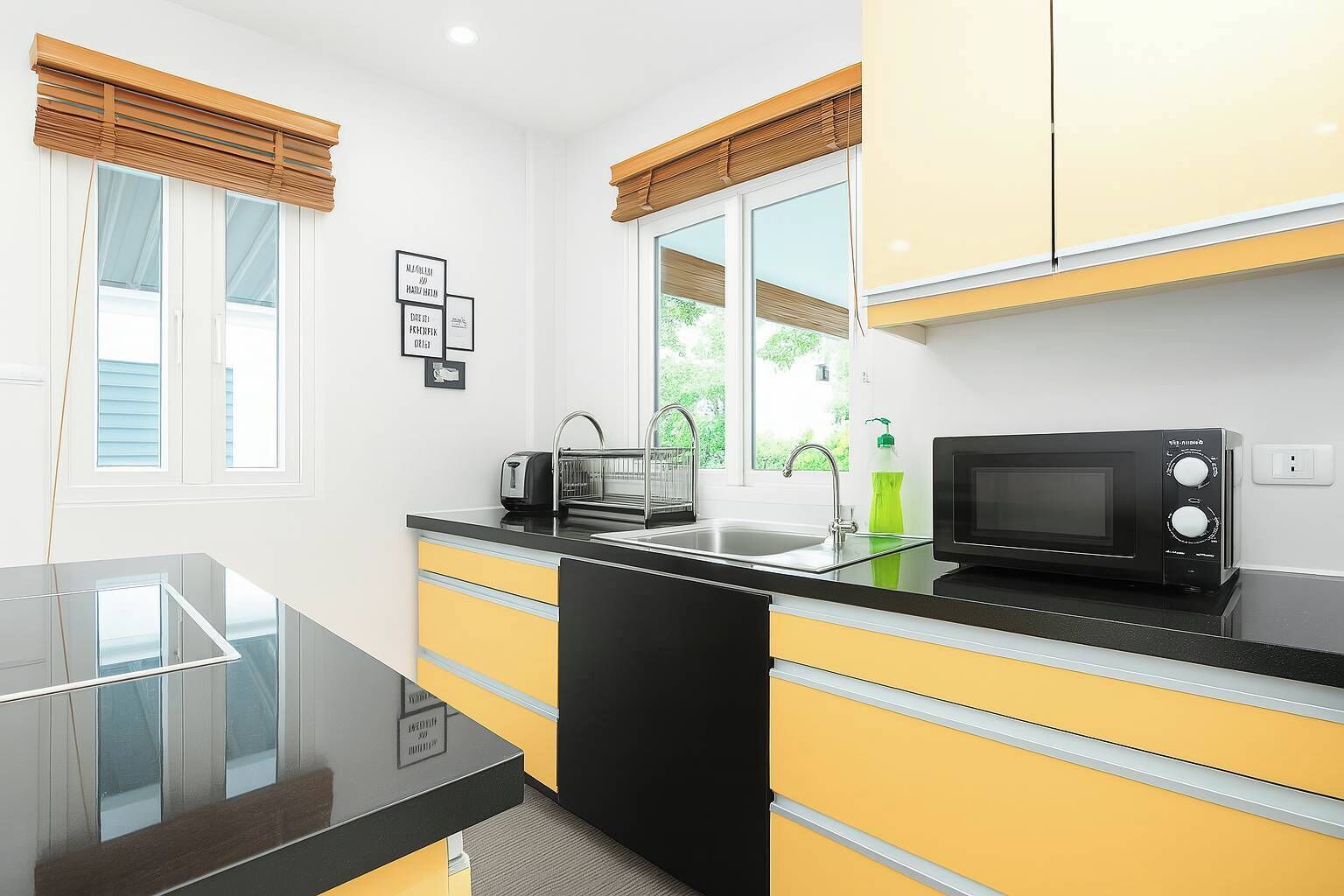 A modern kitchen with a black countertop, yellow cabinets, a black microwave, and a window with blinds.