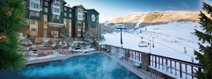 Ein Hotel mit Pool, Skilift und Blick auf einen verschneiten Berg.