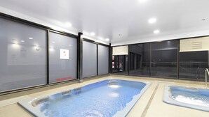 An indoor swimming pool area with multiple hot tubs and a glass wall. - 
Central Emporium | Hotel-Style 1BR w/ King Bed (Melbourne)