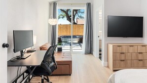 Ein modernes Hotelzimmer mit Schreibtisch, Stuhl und Fernseher.