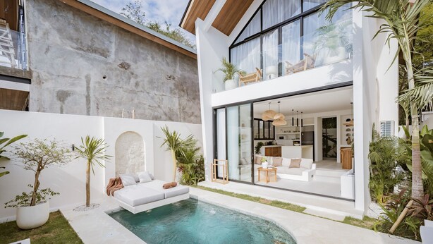A modern house with a swimming pool, outdoor seating, and a large glass window. - Villa Mulia Uluwatu (Pecatu)