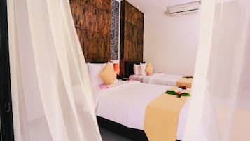 A hotel room with two beds, a wooden headboard, and a decorative wall panel.