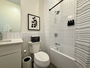 Et badeværelse med toilet, vask og badekar.