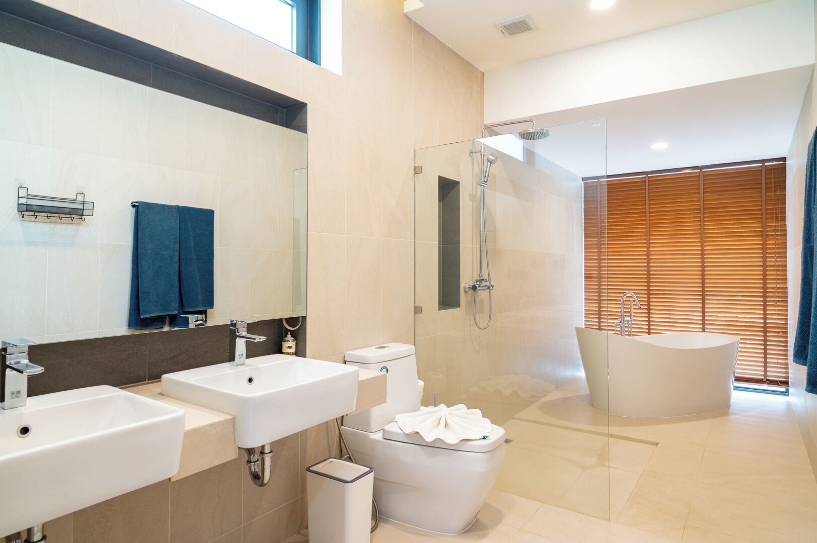 A modern bathroom with two sinks, a toilet, a shower, and a bathtub.