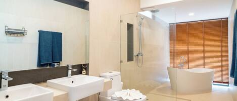 A modern bathroom with two sinks, a toilet, a shower, and a bathtub.