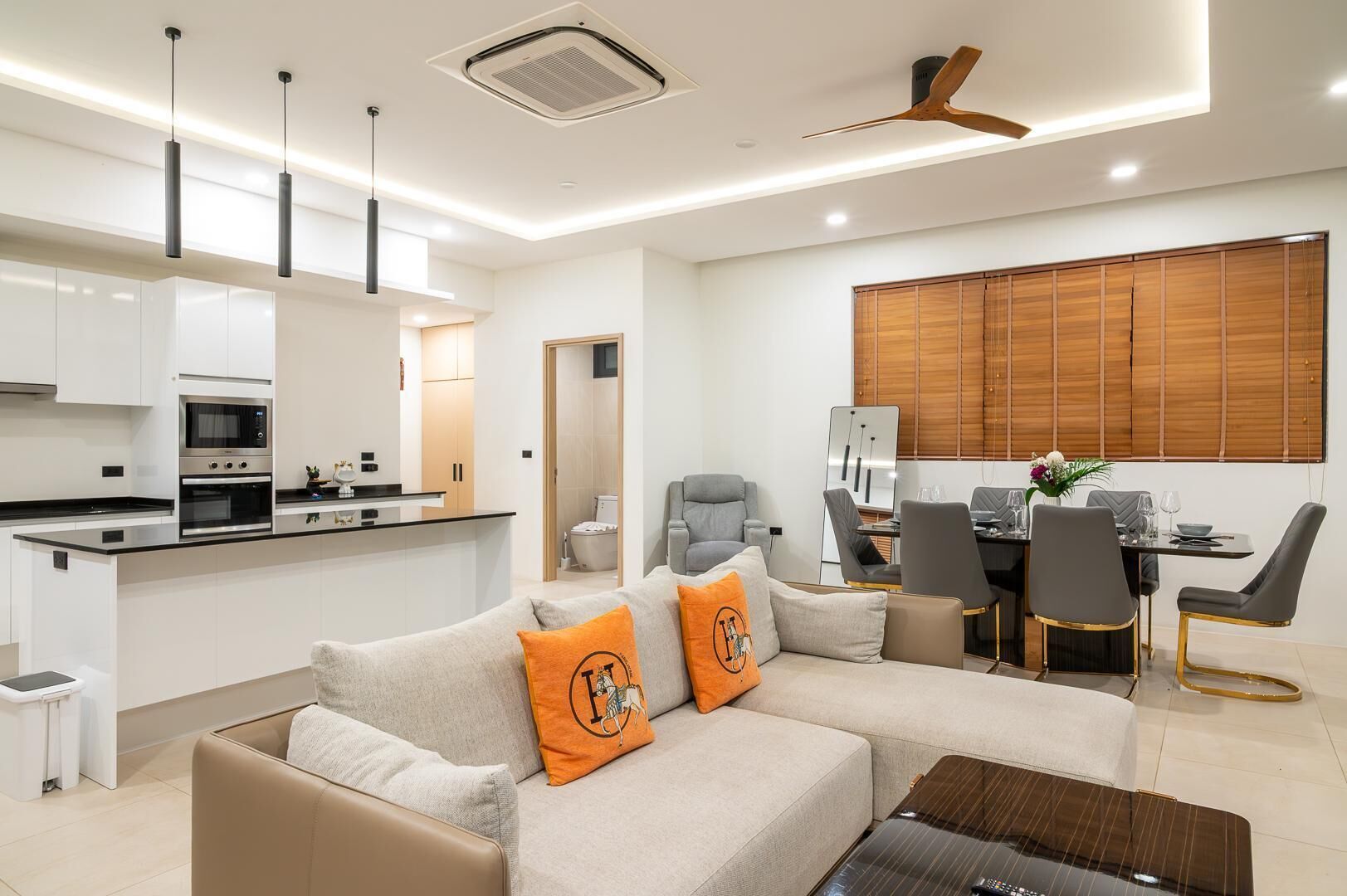 A modern living room with a sofa, coffee table, and dining area.