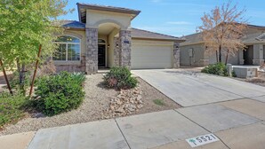 A residential house with a stone facade, a garage, and a driveway.