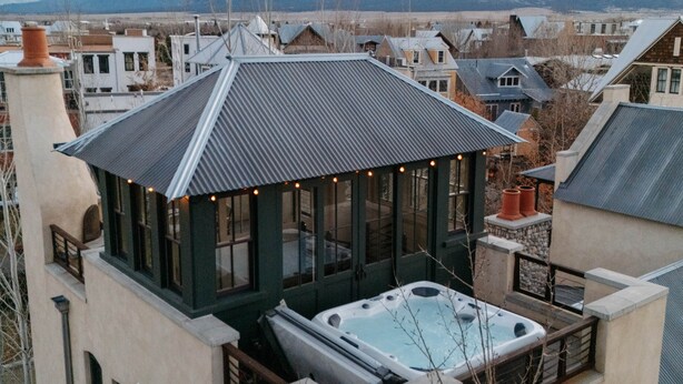 A hot tub on a rooftop with a view of mountains in the background.