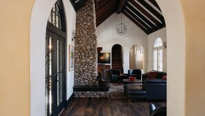 A spacious living area with a stone fireplace, wooden beams, and comfortable seating.
