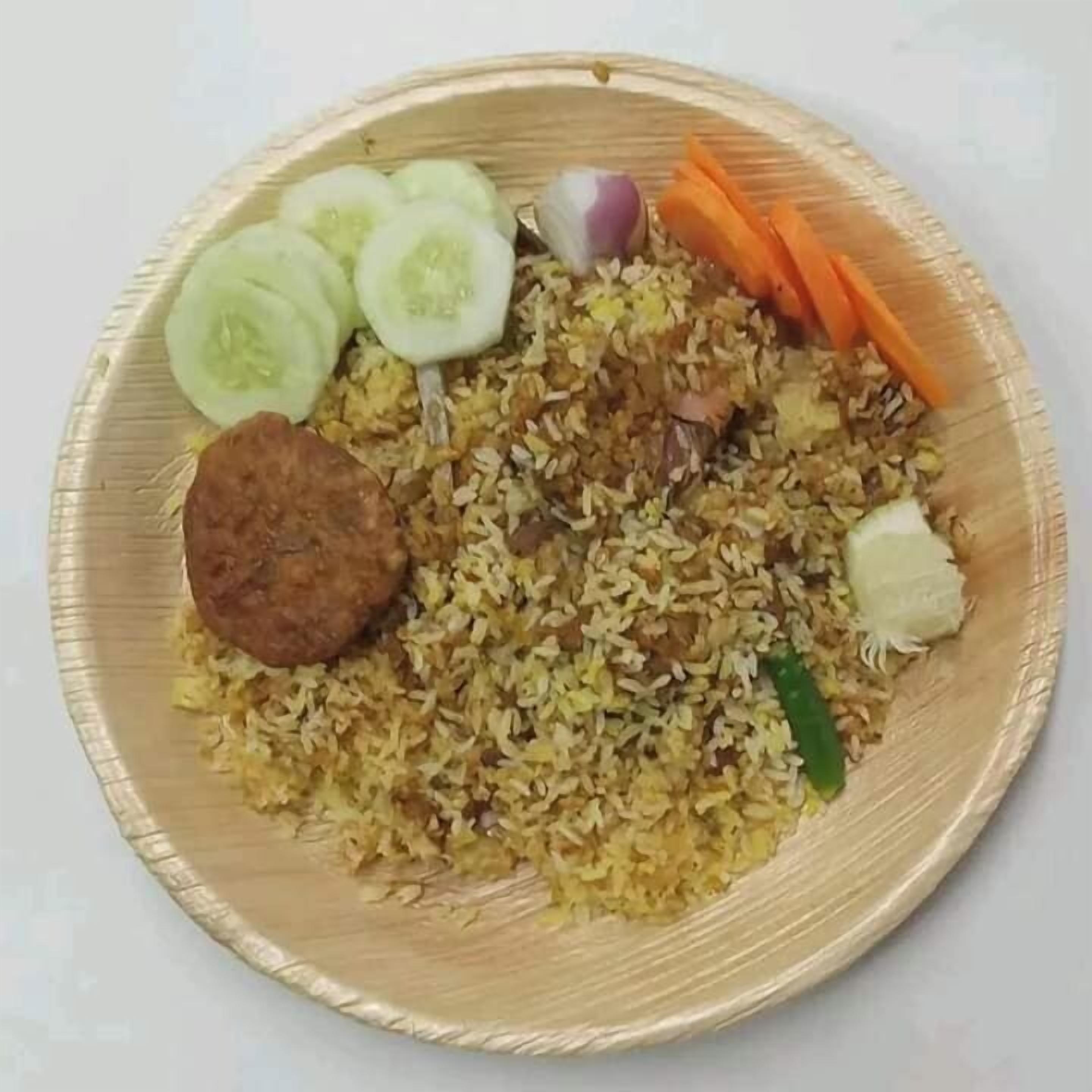 Eine Portion Biryani mit Gurkenscheiben, Karottenstiften und einem Fleischstück.
