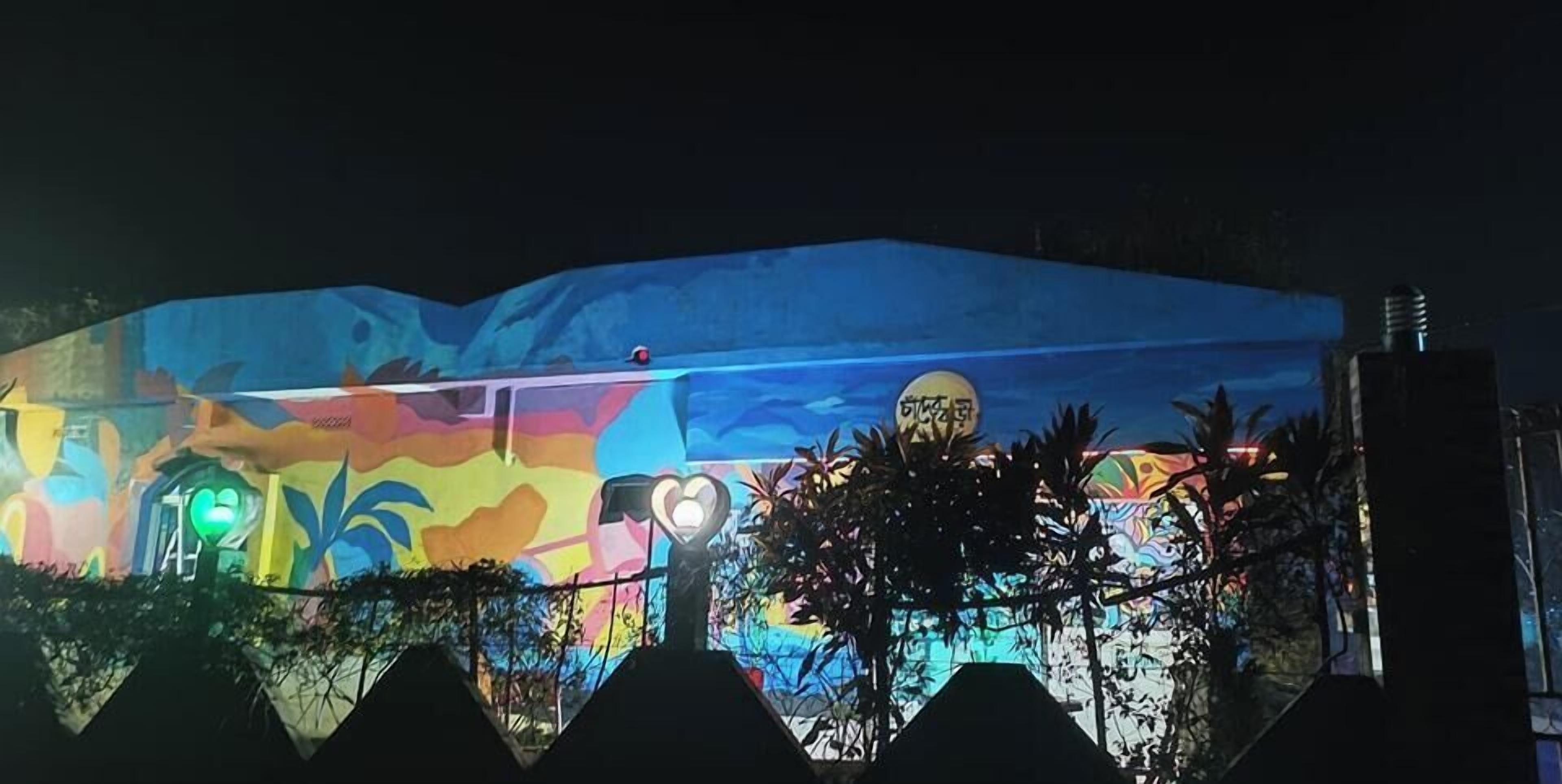 A building with a colorful mural and a green light.